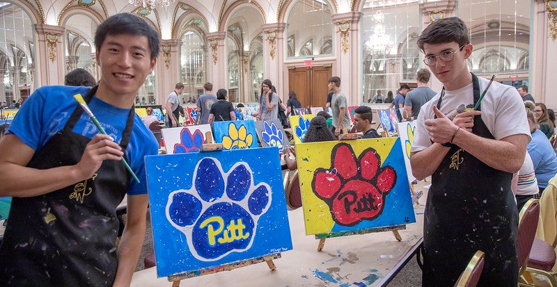 Provost Academy participants show off their paintings from a group activity