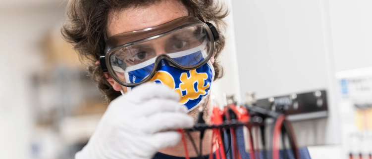 student wearing a mask using lab equipment