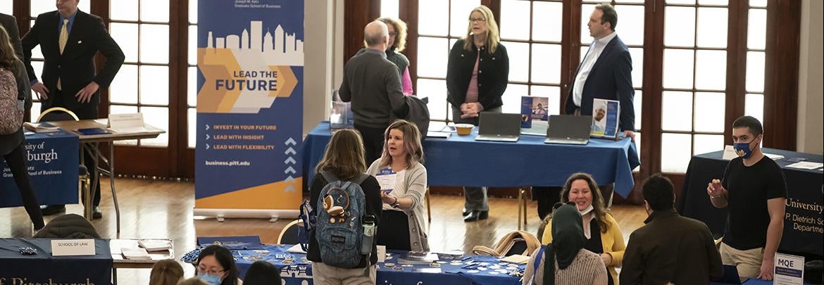 Pitt2Pitt grad fair attendees visit informational tables set up by schools