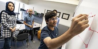 students and professor meeting in informatics classroom